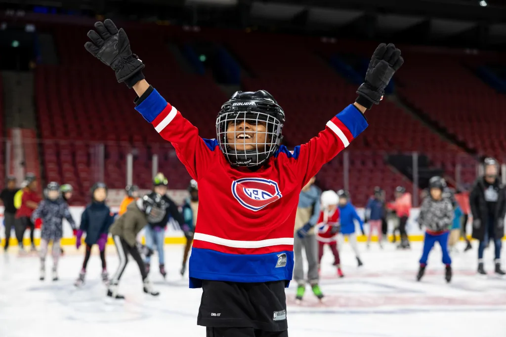 Enfant joyeux qui célèbre sur la glace.