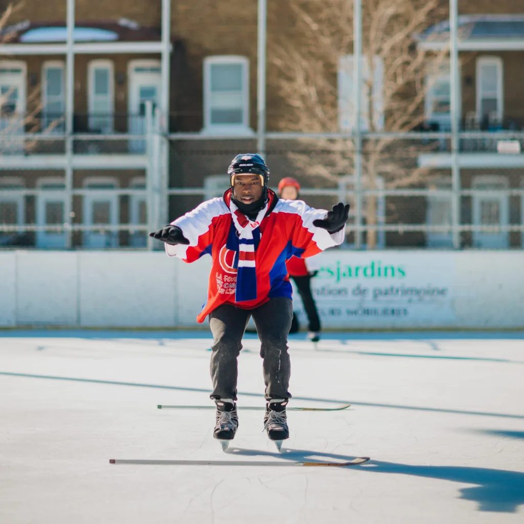Enfant effectuant un saut au dessus de bâtons de hockey lors d’un exercice sur la glace.